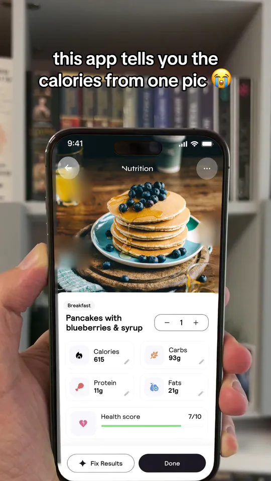 App screen video: a hand holds a phone where a calorie app reads a photo of pancakes, under the line: this app tells you the calories from one pic